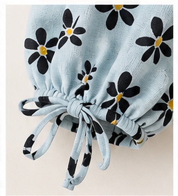 Close-up of the gathered sleeve cuff and tie detail on LOMEE's blue floral top